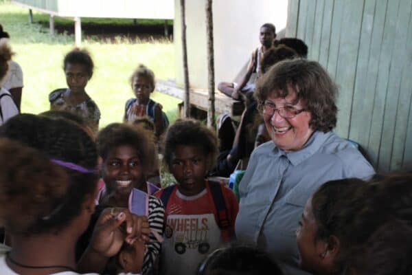 traveler visiting young children at Solomon Island school